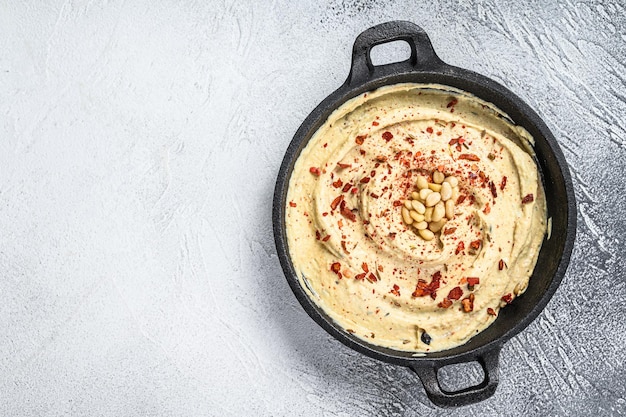 Dip de hummus con garbanzos en un bol. Fondo blanco. Vista superior. Copie el espacio.