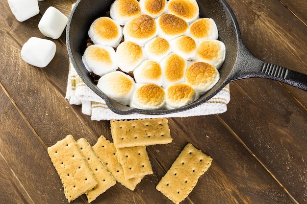 Dip de Smores preparado con grandes malvaviscos en sartén de hierro fundido.