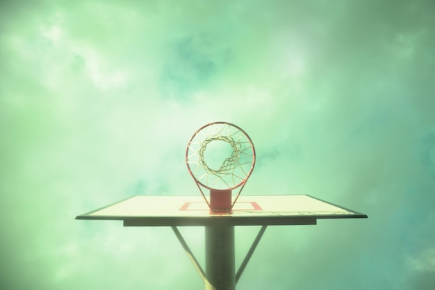 Foto directamente debajo de la toma de un aro de baloncesto contra el cielo