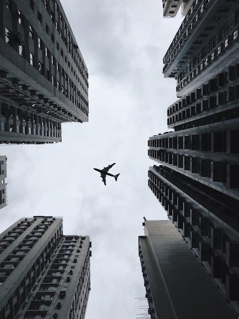 Directamente debajo de la toma de un avión volando contra el cielo en la ciudad