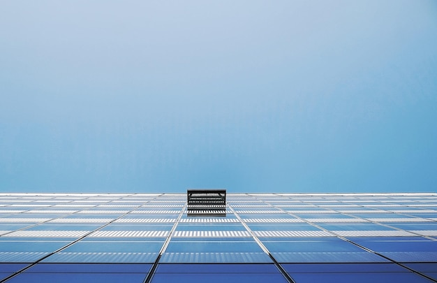 Foto directamente debajo de la toma de un edificio moderno contra un cielo azul claro