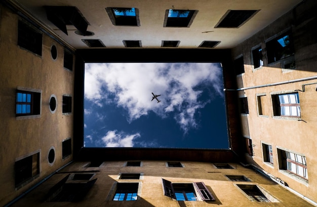 Directamente debajo de la vista del avión volando sobre el edificio contra el cielo