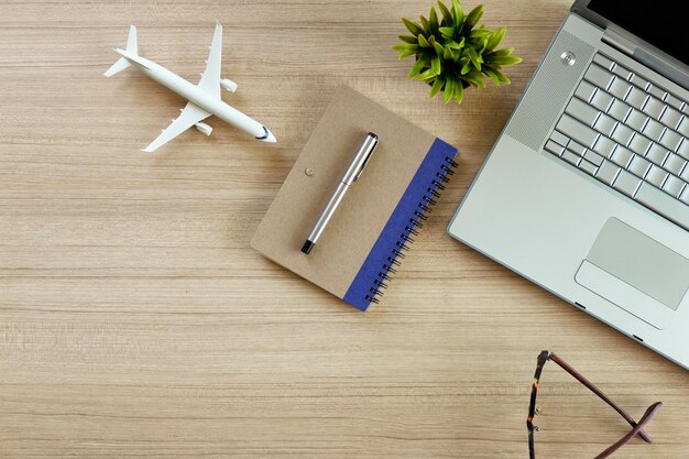 Foto directamente por encima de la computadora portátil y los productos lácteos y el avión en la mesa