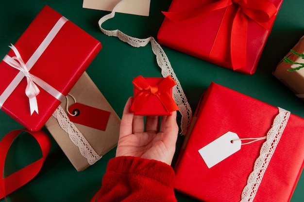 Directamente encima de la mano de la mujer sosteniendo una caja de anillos con regalos para el día de san valentín