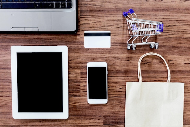 Directamente por encima del pequeño carrito de compras con tarjeta de crédito por electrónica en la mesa