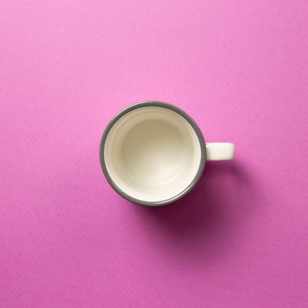 Directamente por encima de la taza de café en la mesa rosa