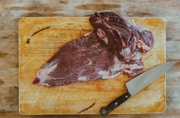 Directamente por encima del tiro de carne con un cuchillo en la tabla de cortar