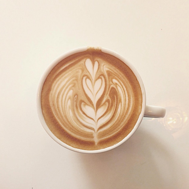 Directamente por encima de la toma de café en la mesa blanca