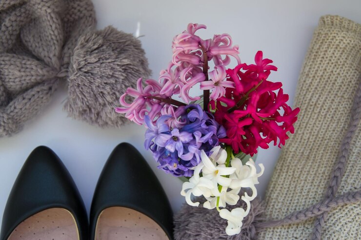 Foto directamente por encima de la toma de flores multicolores por los zapatos en la mesa