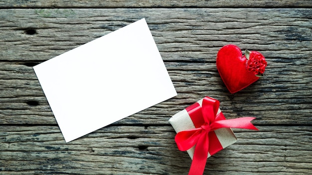 Directamente por encima de la toma en forma de corazón por regalo y papel en blanco en la mesa