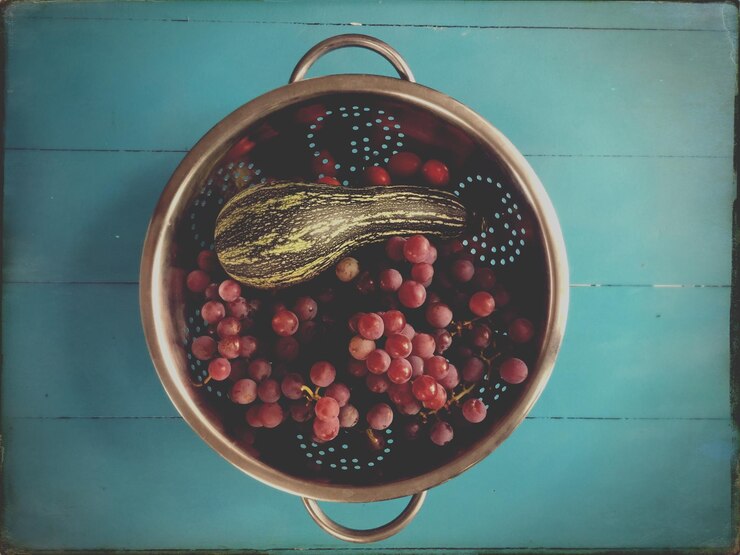 Foto directamente por encima de la toma de frutas en colander en la mesa