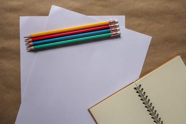 Foto directamente por encima de la toma de lápices con papel y libro en la mesa