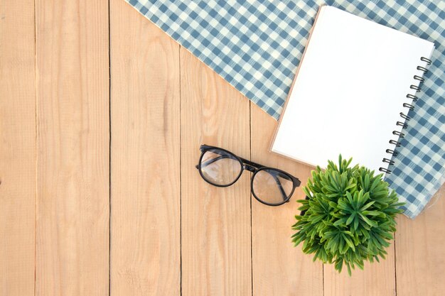 Directamente por encima de la toma de libro y gafas con tela en la mesa