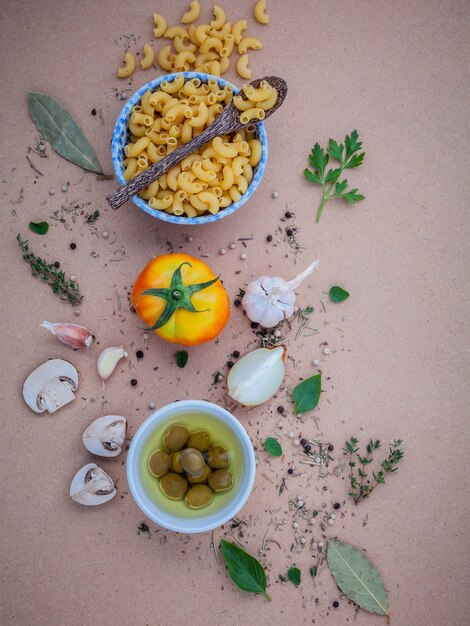 Foto directamente por encima de la toma de pasta cruda y varios ingredientes en la mesa