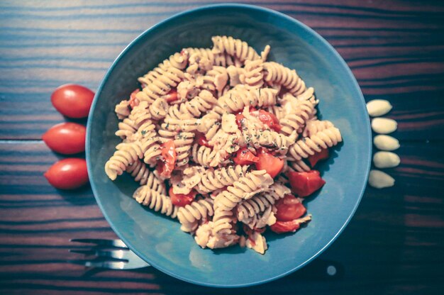 Foto directamente por encima de la toma de pasta servida en un cuenco con los ingredientes en la mesa