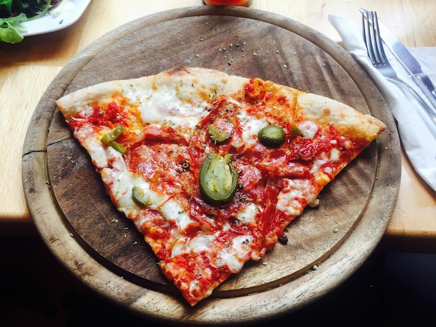 Directamente por encima de la toma de una rebanada de pizza servida en la mesa