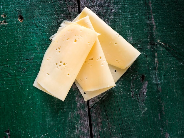 Directamente por encima de la toma de rebanadas de queso en una mesa de madera verde