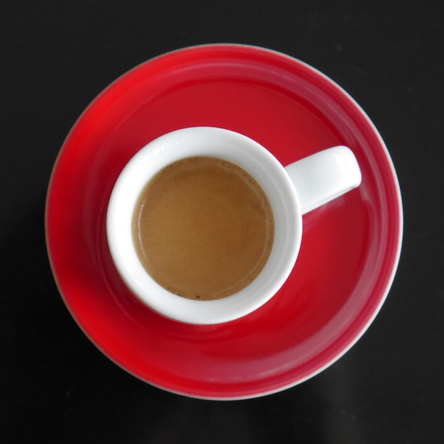 Directamente encima de la toma de la taza de café y el platillo en la mesa
