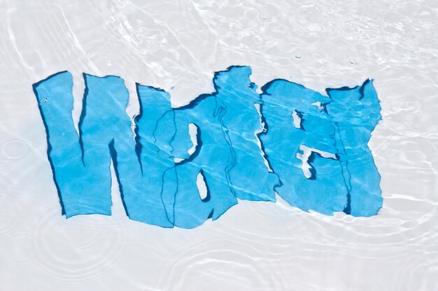 Foto directamente por encima de la toma de texto de agua azul en la piscina