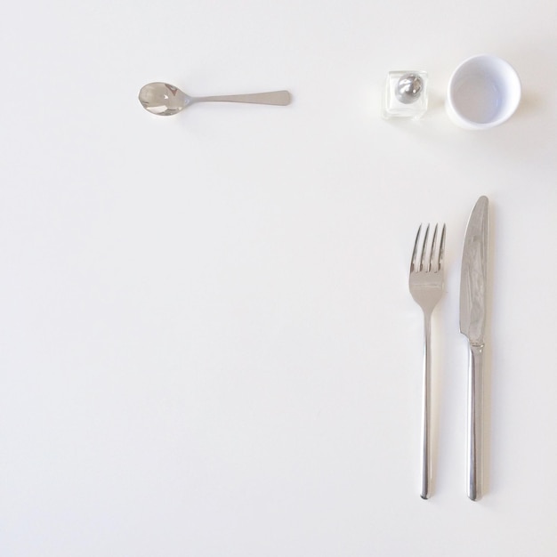 Directamente por encima de la toma de utensilios de comida y leche en taza en la mesa