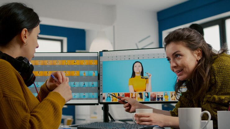 Foto director de arte enseñando a un empleado de retoque cómo colorear gread