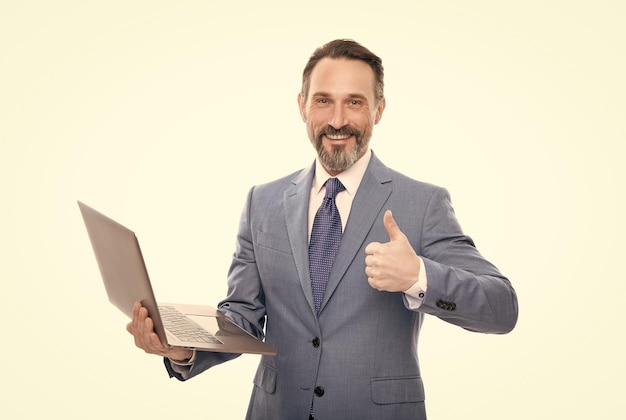 El director feliz usa el trabajo de la computadora inalámbrica en línea aislado en blanco muestra el pulgar hacia arriba la educación empresarial