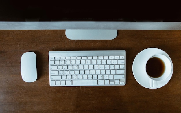 Direkt über dem Bild des Computers und der Kaffeetasse auf dem Tisch