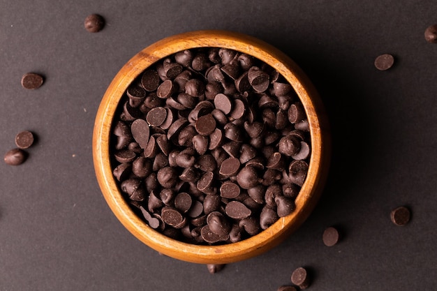 Direkt über dem Blick auf frische Schokoladenstückchen in einer Holzschale auf farbigem Hintergrund