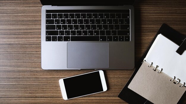 Foto direkt über dem laptop mit mobiltelefon und buch auf dem tisch