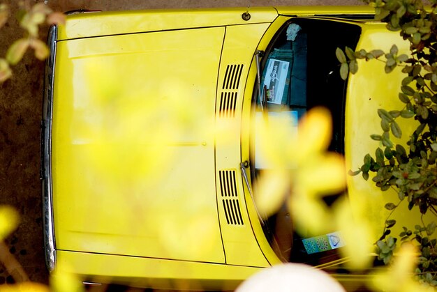 Foto direkt über dem schuss von einem gelben auto auf dem parkplatz