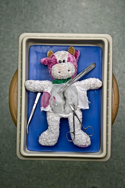 Foto direkt über dem spielzeug mit chirurgischen geräten in einem medizinischen tablett auf dem tisch