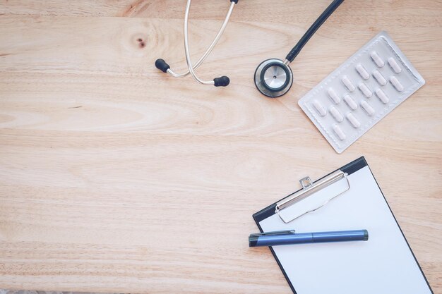 Foto direkt über dem stethoskop von medizin und schreibtafel auf dem tisch