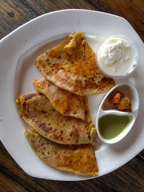 Direkt über dem Tisch eine Sicht auf frische Paratha, die auf einem Teller serviert wird