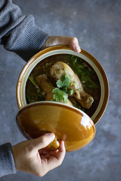 Foto direkt über der aufnahme einer person, die chinesische hühnersuppe hält