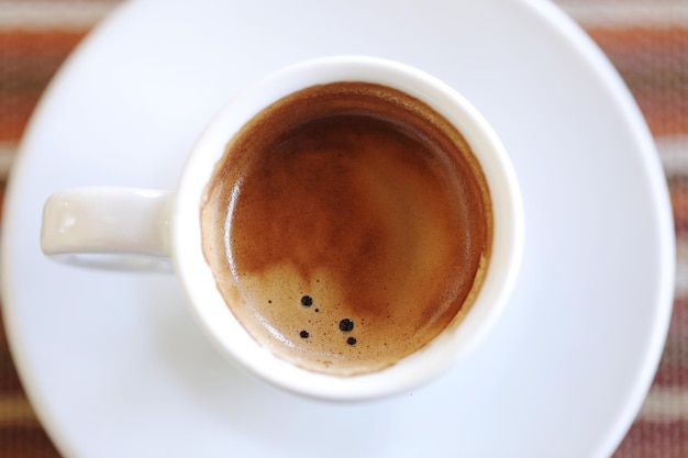 Direkt über der Kaffeetasse auf dem Tisch