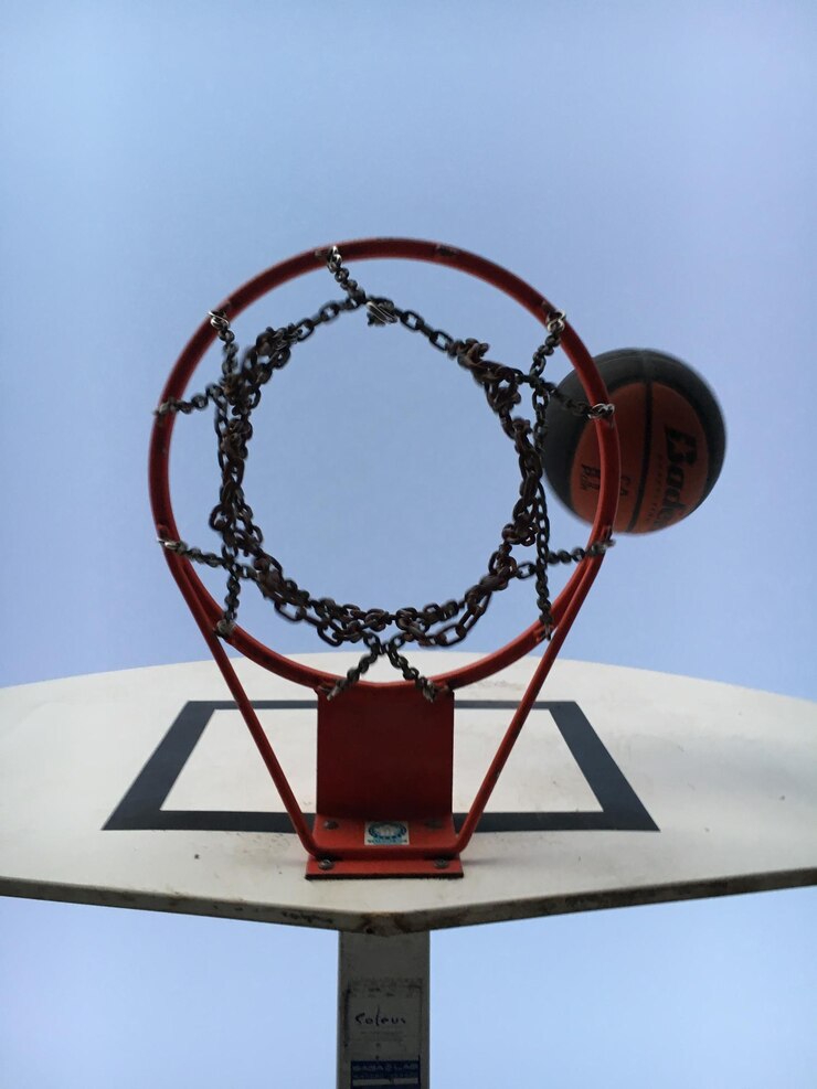 Foto diretamente abaixo tiro de basquete por aro contra o céu claro