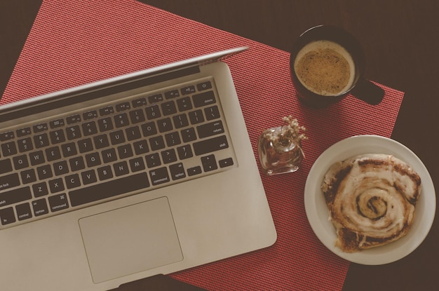 Diretamente acima da foto da xícara de café pelo portátil na mesa