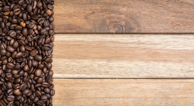 Diretamente acima da foto de grãos de café torrados em uma mesa de madeira
