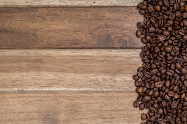Diretamente acima da foto de grãos de café torrados em uma mesa de madeira