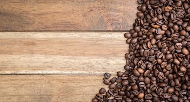 Diretamente acima da foto de grãos de café torrados em uma mesa de madeira