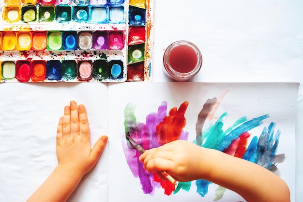 Diretamente acima da foto de mãos cortadas pintando em papel