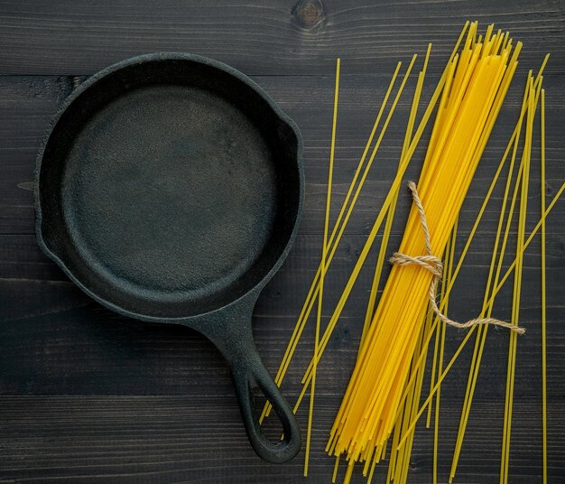 Diretamente acima da foto de massa não cozida com utensílios de cozinha na mesa