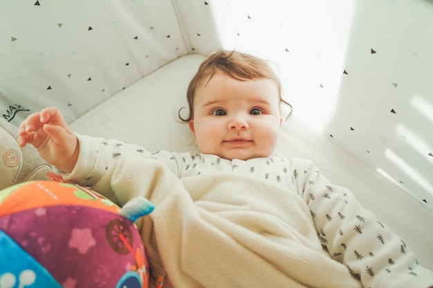 Diretamente acima da foto de uma menina bonita deitada na cama em casa.