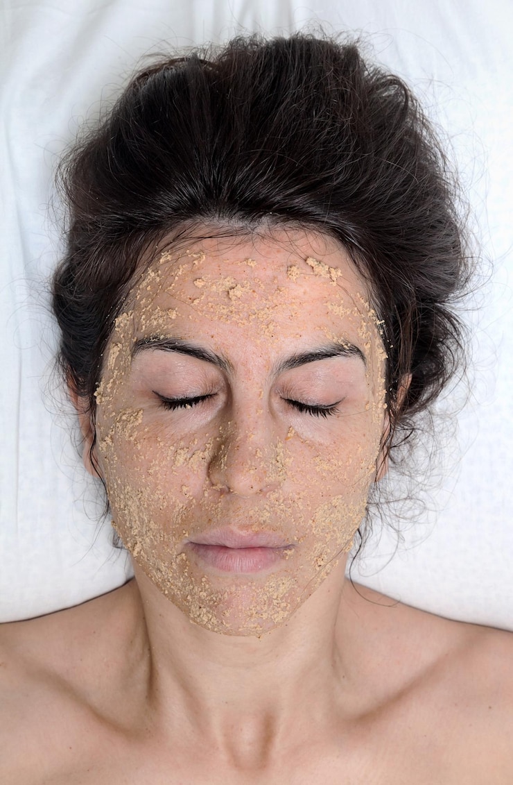 Foto diretamente acima da foto de uma mulher com máscara facial dormindo na cama