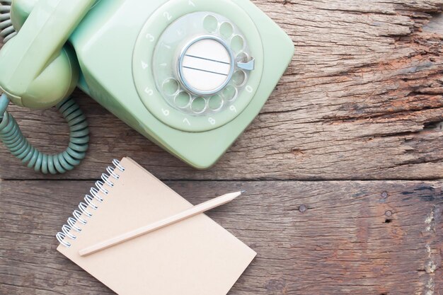 Foto diretamente acima da foto do diário com telefone rotativo na mesa