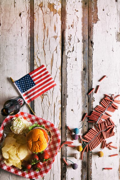 Foto diretamente acima da foto do hambúrguer com a bandeira americana no prato na mesa