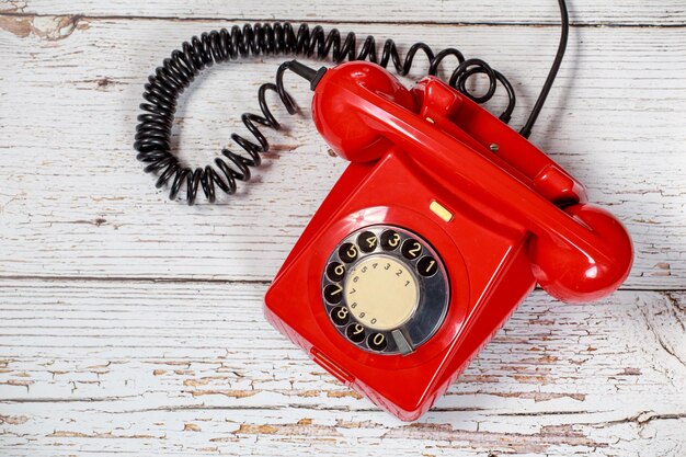 Foto diretamente acima da foto do telefone rotativo vermelho na mesa de madeira