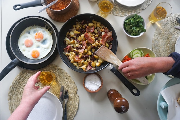 Foto diretamente acima da mesa com ovos e bacon com mais