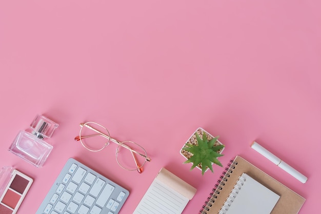 Diretamente acima da mesa de escritório com teclado em fundo rosa