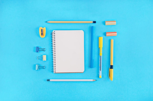 Diretamente acima de uma foto de materiais escolares sobre um fundo azul